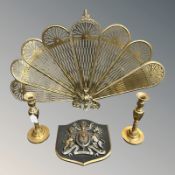 A brass peacock firescreen, height 57 cm, a pair of candlesticks and a ceramic royal crest.