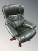 A Scandinavian green stitched leather swivel lounge armchair.