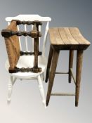 An elm stool, a painted spindle back chair and a rush seated stool.