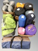 A collection of camping equipment including tent, several sleeping bags, some retaining retail tags.