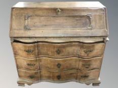 A 19th century continental oak serpentine fronted bureau,