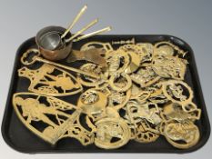 A quantity of horse brasses, trivets, oversized key, small set of graduated saucepans.