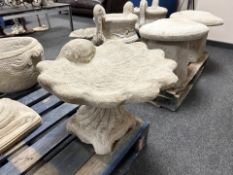 A concrete garden shell design bird bath.