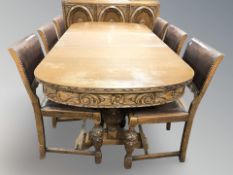 A 1930's carved oak eight piece dining room suite comprising extending table,