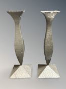 A pair of hammered pewter Arts and Crafts style candlesticks