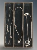 Three silver necklaces with pendants.