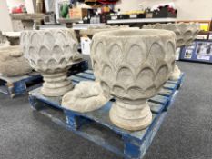 A pair of concrete pineapple garden urns.
