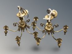 A pair of brass five branch chandeliers.