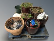 A pallet of garden plant pots, terracotta plant pot and bag of gravel.