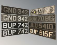 Eight vintage metal vehicle registration plates.