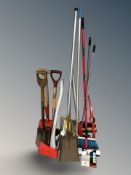 A group of tools, brush, tree lopper, axe, spades, etc.