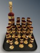 A group of red glass gilded goblets with decanter