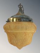 An early 20th century brass and multi coloured glass light shade.