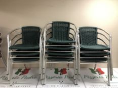 A stack of ten green tubular steel chairs