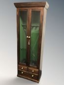 A reproduction mahogany gun cabinet, with some cleaning rods internally, fitted with three drawers,