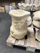 A concrete toby jug planter.