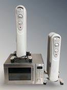 An oil-filled radiator together with a stainless steel microwave.