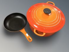 A Le Creuset cast iron casserole pan with lid together with small frying pan