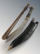 A turned wooden truncheon, length 38 cm, and a reproduction kukri in sheath.