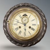 A carved oak ship's eight day wall clock.
