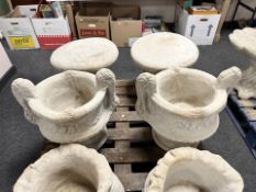 A pair of twin handled concrete garden urns.