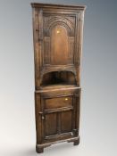 A carved oak corner cabinet, width 59 cm.