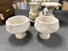 A pair of concrete jardinieres on stands.