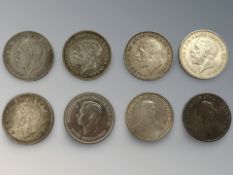 Seven silver crown-sized coins and a 1951 crown