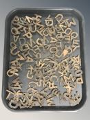 A box containing a large quantity of brass letters.