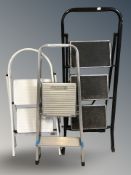 Three sets of metal folding steps.