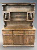 A reproduction oak dresser, 142 cm x 52 cm x 184 cm.