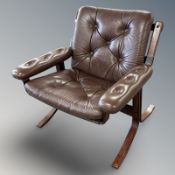 A Danish stained bent wood and button brown leather armchair,