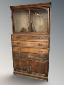 A Victorian oak cabinet fitted with drawers, cupboards and sliding glass doors above,