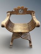 An early 20th century oak Savonarola-style armchair,