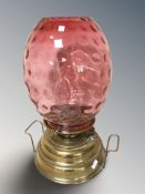 A late Victorian brass and cranberry glass oil lamp, height 45 cm.