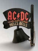 A cast iron AC/DC wall bell on bracket, height 34 cm.