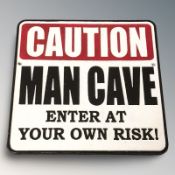 A cast iron 'Man Cave' plaque, width 25 cm.