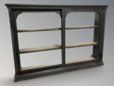 A Victorian ebonised and glazed sliding door wall display cabinet,
