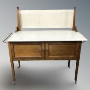 A late Victorian and marble topped wash stand with glazed back,
