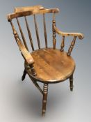 A beech spindle back elbow chair.