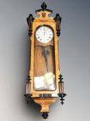 A walnut and ebonised Vienna eight day wall clock with enameled dial, pendulum and key,