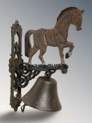 A cast iron horse wall bell on bracket, length 34 cm.