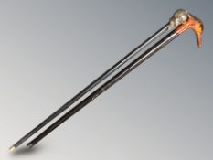 A walking stick with duck's head pommel and another with the bust of a man.