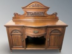 A late Victorian carved bow-front sideboard,
