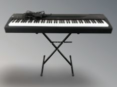 A Yamaha electronic piano P-60, with lead, pedal and folding stand.