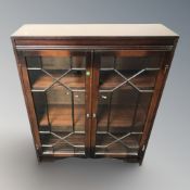 A glazed mahogany double door bookcase, 81 cm x 25 cm x 102 cm.
