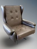 A late 20th century Danish buttoned brown leather swivel armchair,