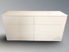 A contemporary white laminated six drawer chest, 160 cm x 49 cm x 78 cm.