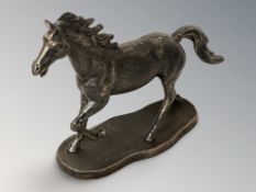 A bronzed metal figure of a stallion on plinth, length 25 cm.