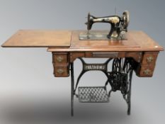 A Singer sewing treadle sewing machine in walnut table.